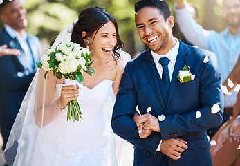 Image showing Love, laughing and couple walking at their wedding with guests in celebration of romance. Happy, smile and young bride with bouquet and groom with crowd celebrating at the outdoor marriage ceremony.