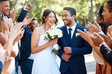 Image showing Couple, wedding and guests clapping hands in celebration of love, romance and union. Happy, smile and young bride with a bouquet and groom walking by crowd cheering for marriage at an outdoor event.