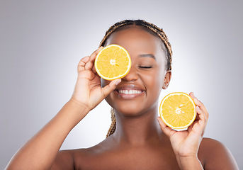 Image showing Beauty, orange and cover with black woman in studio for natural, cosmetics or vitamin c. Nutrition, skincare and detox with face of female model on grey background for citrus fruit and health product