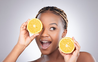 Image showing Glow, orange and skincare with black woman in studio for natural, cosmetics and vitamin c. Nutrition, diet and detox with face of female model on grey background for citrus fruit and health product