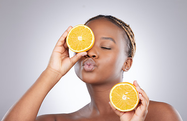 Image showing Beauty, orange and kiss with black woman in studio for natural, cosmetics and vitamin c. Nutrition, diet and detox with face of female model on grey background for citrus fruit and health product