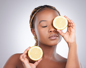 Image showing Beauty, lemon and skincare with black woman in studio for natural, cosmetics and vitamin c. Nutrition, diet and detox with face of female model on grey background for citrus fruit and health product