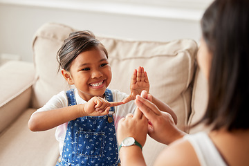 Image showing Sign language, learning and girl kid with her mother in the living room of their family home. Happy, smile and child speaking with her hands to her deaf mom to communicate in their modern house.