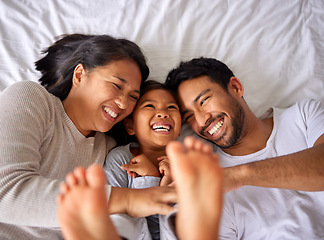 Image showing Fun, bed and happy family playing, wake up and happy from above, tickle and laughing in their home. Bedroom, games and girl with parents, smile and laugh, relax and love in their house on the weekend