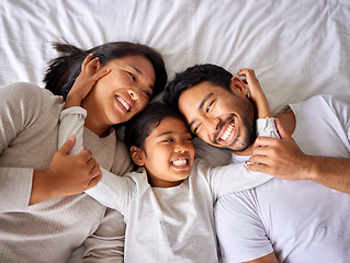 Image showing Love, face and family in bed from above happy, smile and bonding in their home together. Hug, girl child and top view of parents with their daughter in a bedroom, relax and embracing indoors