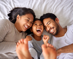 Image showing Bed, fun and happy family playing, wake up and happy from above, tickle and laughing in their home. Bedroom, games and girl with parents, smile and laugh, relax and love in their house on the weekend