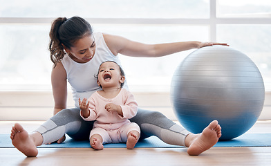 Image showing Woman, happy baby and floor with exercise ball, laughing and bonding together with fitness, health and wellness. Workout, mother and daughter with happiness, home and excited face for training in gym