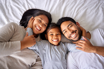 Image showing Portrait, love and family in bed from above happy, smile and bonding in their home together. Face, girl child and top view of parents with their daughter in a bedroom, relax and embracing indoors