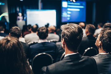 Image showing Speaker giving a talk in conference hall at business event. Rear view of unrecognizable people in audience at the conference hall. Business and entrepreneurship concept.