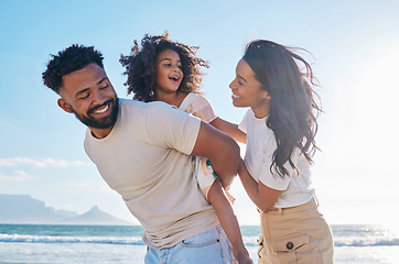 Image showing Happy family, travel and parents with a child at the beach excited for a sea or ocean vacation together in happiness. Young, mother and father playing piggyback with a kid on a holiday in summer