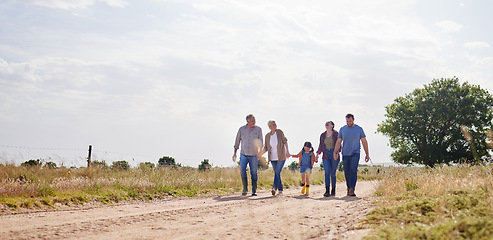 Image showing Love, happy family walking holding hands and on a farm with blue sky. Support or care, happiness or agriculture and people walk outdoors by countryside or rural environment together with generation