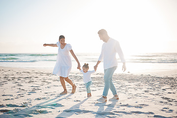 Image showing Happy family, holding hands and playing on beach with mockup space for holiday weekend or vacation. Mother, father and child enjoying play time together on ocean coast for fun bonding in nature