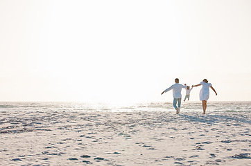 Image showing Family, holding hands and playing on beach with mockup space for holiday weekend or vacation. Mother, father and child enjoying quality play time together for fun bonding or travel in nature outdoors