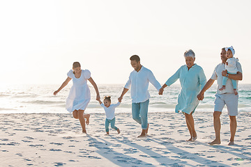 Image showing Big family, holding hands and walking on beach for holiday weekend or vacation with mockup space. Grandparents, parents and kids on a ocean walk together for fun bonding or quality time in nature