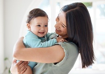 Image showing Mother holding happy baby in home for love, care and quality time together to nurture childhood development. Mom, infant kid and carrying little girl for support, happiness and smile with fun parent