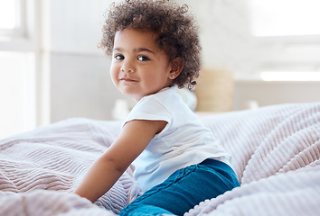Image showing Happy portrait, girl and kid in bedroom for fun, childhood development and baby growth with curly hair. Cute, adorable and sweet toddler, young child or relaxing on comfortable bed in nursery at home