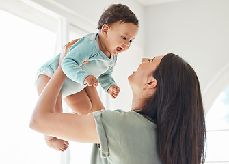 Image showing Mother holding laughing baby in home for love, care and quality time together to nurture childhood development. Happy mom, carrying and playing with infant girl kid for support, happiness and fun