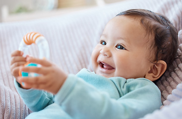 Image showing Happy baby, rattle and child in bedroom for childhood development, growth and cute smile at home. Adorable young girl, infant kid and playing with toys for happiness, fun and relax in nursery room