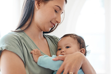 Image showing Mother holding baby in arms for love, care and quality time together to nurture childhood development at home. Mom carrying infant girl kid, young child and newborn for support, comfort and childcare