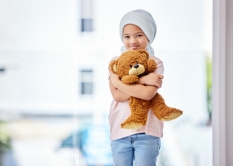 Image showing Healthcare, child and portrait of a cancer patient holding a teddy bear for support or comfort. Medical, smile and girl kid with leukemia standing with a toy after treatment in a medicare hospital.