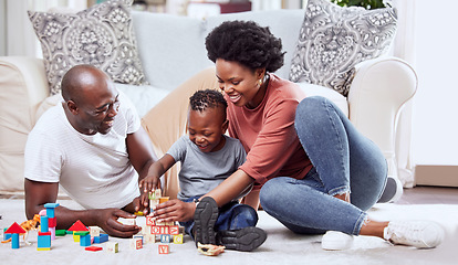 Image showing Building blocks, toys and black family playing on a living room floor happy, love and bonding in their home. Child development, learning and kid with parents in a lounge with alphabet, shape and game