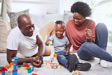 Image showing Building blocks, games and black family playing on a living room floor happy, love and bonding in their home. Child development, learning and kid with parents in lounge with alphabet, shape and toys