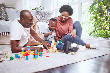 Image showing Toys, building blocks and black family playing on a living room floor happy, love and bonding in their home. Child development, learning and kid with parents in a lounge with alphabet, shape and game