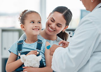 Image showing Girl, mom and doctor with vaccine injection, cotton ball and flu shot on arm for disease or covid prevention in hospital. Woman, nurse and child with pediatrician help with bandaid, teddy or health