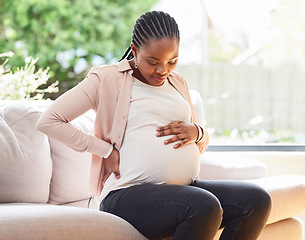 Image showing Back pain, stomach and relax with pregnant woman on sofa for labor, healthcare and maternity. Ache, spine and emergency with African mother in living room of home for pregnancy and uncomfortable