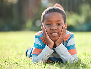 Image showing Nature park, portrait of black boy and lying on grass outside. Summer vacation or holiday break, happiness or cheerful and barefoot with young male person relaxing on a field outdoors on lawn