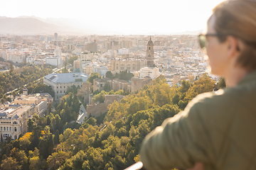 Image showing Bolnde female touris enjoying amazing panoramic aerial view of Malaga city historic center, Coste del Sol, Andalucia, Spain.