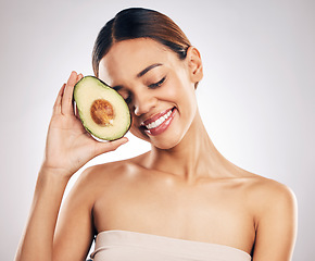 Image showing Happy, skincare and woman with avocado in studio for natural, cosmetics or facial on grey background. Smile, glow and girl model with fruit for vegan, environmental or skin detox with collagen