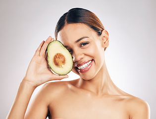 Image showing Woman, skincare and avocado in studio portrait for health, wellness or facial glow by white background. Girl, model and healthy skin with fruit, makeup or cosmetics for self care, aesthetic and smile