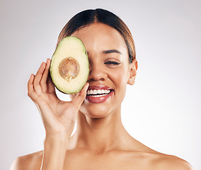 Image showing Skincare, smile and woman with avocado in studio for organic, facial or treatment on grey background. Face, avo and girl model with fruit for eco, vegan or skin detox with anti aging or antioxidants