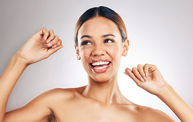 Image showing Smile, dental floss and woman in studio for mouth, teeth and wellness, hygiene or fresh breath on grey background. Flossing, happy and girl model cleaning gum, tooth and bacteria or cavity prevention