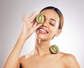 Image showing Kiwi, skincare and happy woman in studio for beauty, wellness or self love with natural cosmetic on grey background. Organic, treatment and female model with fruit for hyperpigmentation prevention