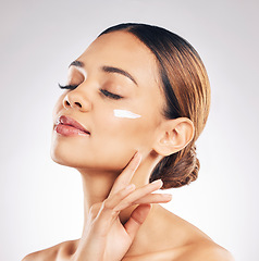 Image showing Skincare, face cream and woman relax in studio for cosmetic, wellness or self love on grey background. Facial, beauty and female model with sunscreen, moisturizer or collagen mask for hydration