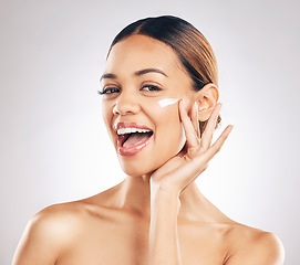 Image showing Happy woman, cream on face and beauty with skincare, smile and moisturizer isolated on studio background. Excited female model apply lotion, dermatology and cosmetic product with skin glow and facial