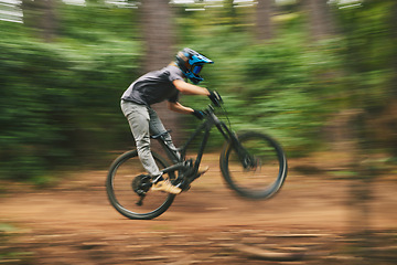 Image showing Sports, bike and man doing adrenaline stunt with energy while riding fast for competition practice in woods. Fitness, blur motion and male athlete biker with training or exercise in an outdoor forest