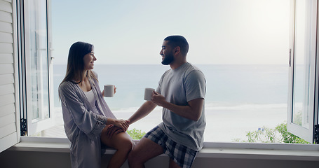 Image showing Couple, coffee and window on holiday by sea with conversation, romance and love in summer sunshine. Woman, man and drink with latte, morning or matcha on vacation with ocean view in home with bond