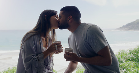 Image showing Couple, kiss and coffee in morning on balcony with love, romance and care on holiday by ocean with sunshine. Man, woman and trust with drink, espresso or matcha on vacation by sea with bond in summer