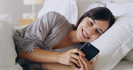 Image showing Happy, woman and texting on cellphone in bedroom for online dating app, reading social media notification and relax. Female typing on smartphone in bed, morning and mobile internet download at home