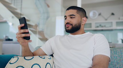 Image showing Man, cellphone and typing on sofa in living room, reading social media post and online blog. Young male person, relax and texting on smartphone, download mobile games and website connection at home