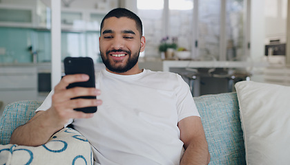 Image showing Happy, man and typing on smartphone in living room, reading social media post and online blog. Young male person, smile and relax with cellphone, download mobile games and website connection at home