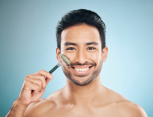 Image showing Happy man, portrait or face massage with jade roller, facial product for healthy skincare on studio background. Relaxing, grooming treatment or male model smiling with dermatology cosmetics or beauty