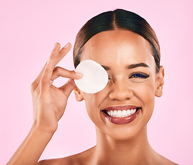 Image showing Happy woman, face and cotton pad in makeup removal, skincare or cosmetics against a pink studio background. Portrait of excited female person with cosmetic swab in beauty cleaning or facial treatment