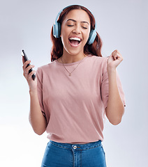 Image showing Mobile, headphones or happy woman dancing to music or singing radio songs in studio on white background. Dance, smile or excited girl streaming or listening to audio playlist with cellphone or energy