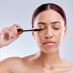 Image showing Beauty, face and woman with mascara makeup, cosmetics and product brush on eye, lashes and studio background. Cosmetic, closed eyes and model with eyelashes tool for make up, skincare and self care