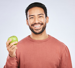 Image showing Man in portrait, apple and nutrition with health and diet with eating isolated on white background. Male person with smile, green fruit and organic with healthy food, detox and lose weight in studio