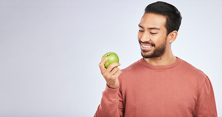 Image showing Man, apple and nutrition, health and diet, mockup space and eating isolated on studio background. Male person with smile, green fruit and organic with healthy food, vegan with detox and lose weight